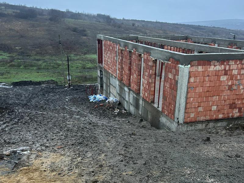 Casă în construcție cu fundație, stâlpi și centuri din beton armat